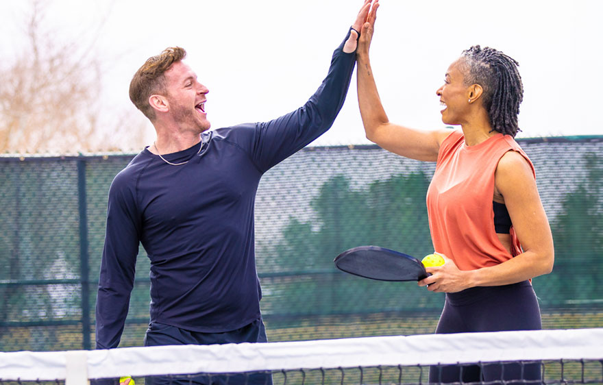 Two adults playing pickle ball